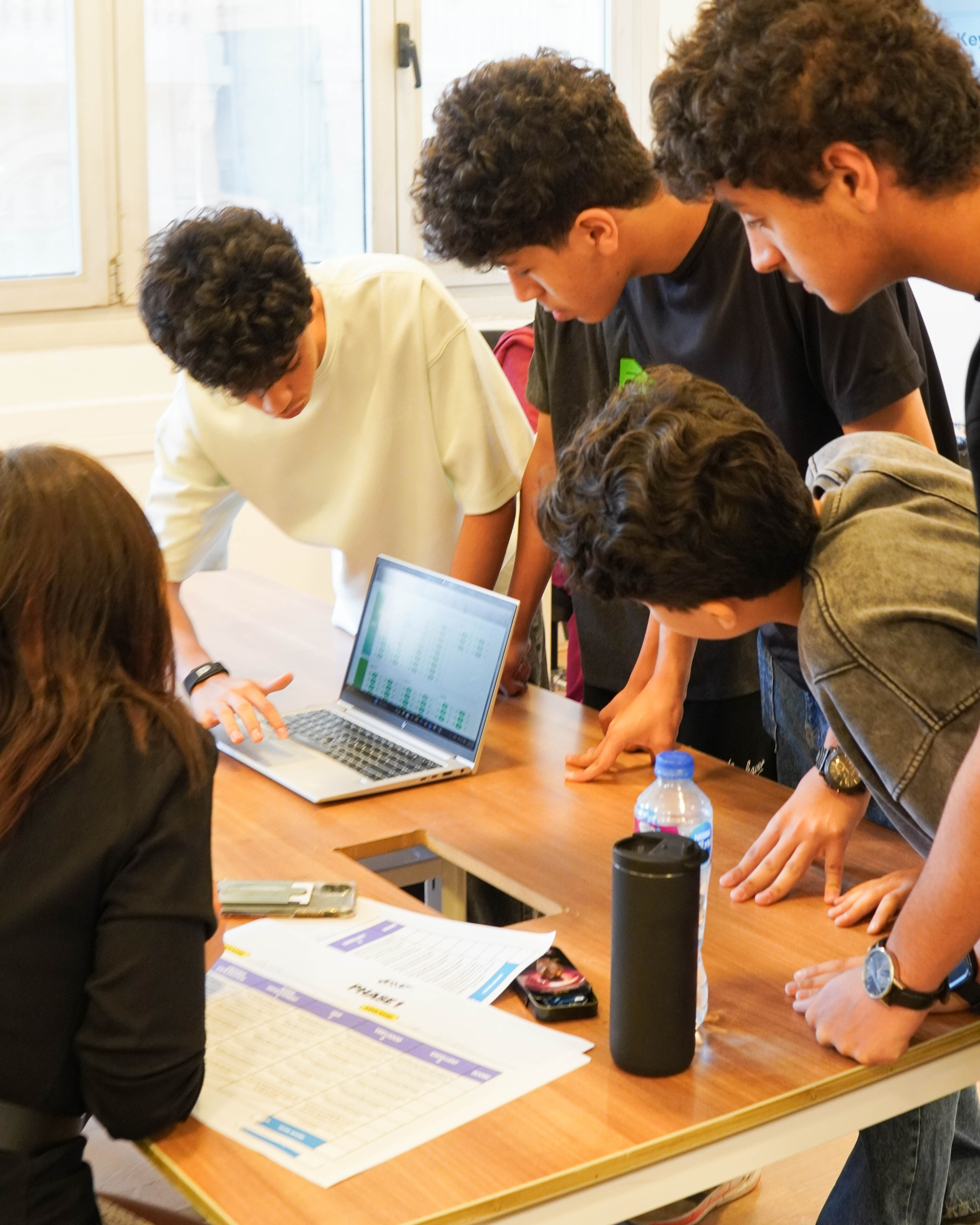 Students working together around a laptop